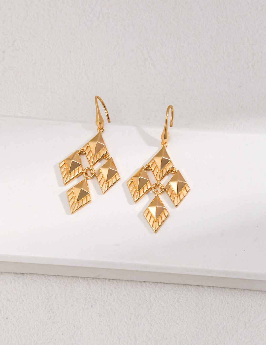 Stylish gold earrings featuring intricate geometric shapes.Gold plated rhombus earrings with geometric designs.