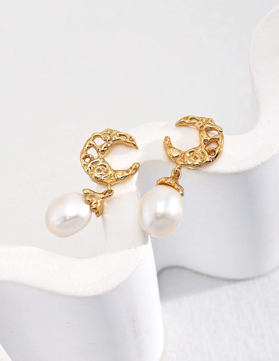 Gold plated earrings with crescent moon charm and freshwater pearl dangles.