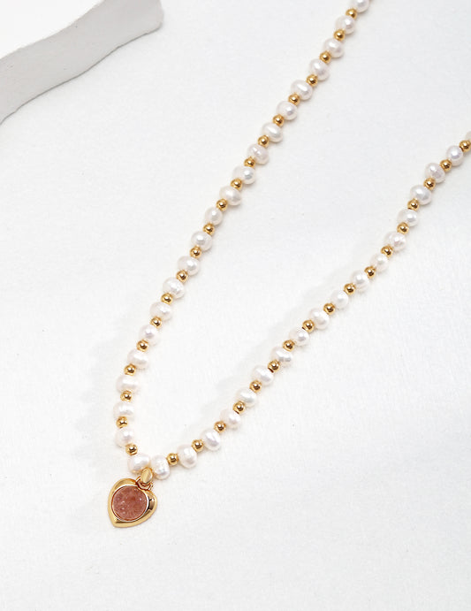 A beautiful gold heart necklace with pearls and strawberry quartz.