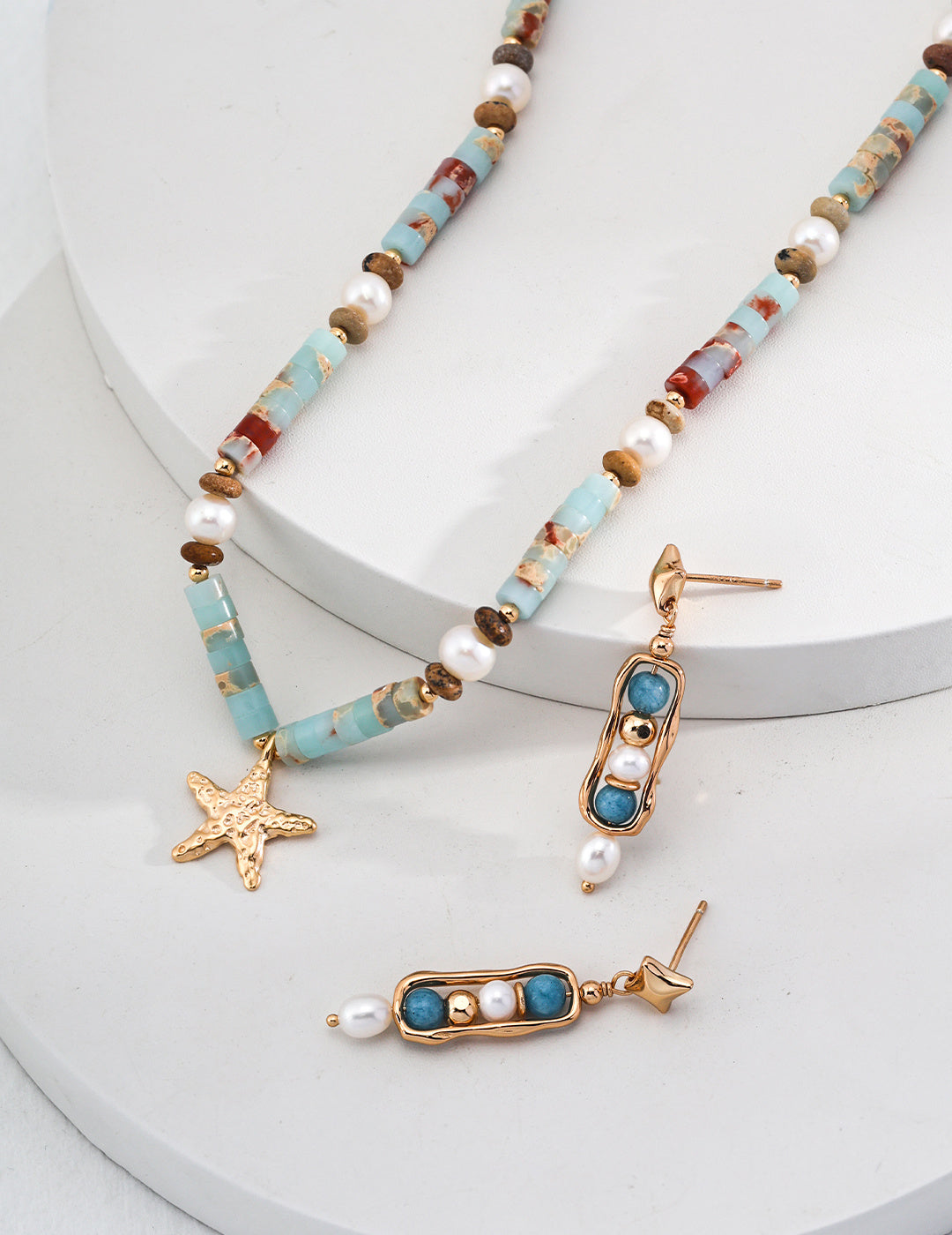 Stunning turquoise bead necklace and earring set adorned with gold starfish, enhanced by beautiful agalmatolite.