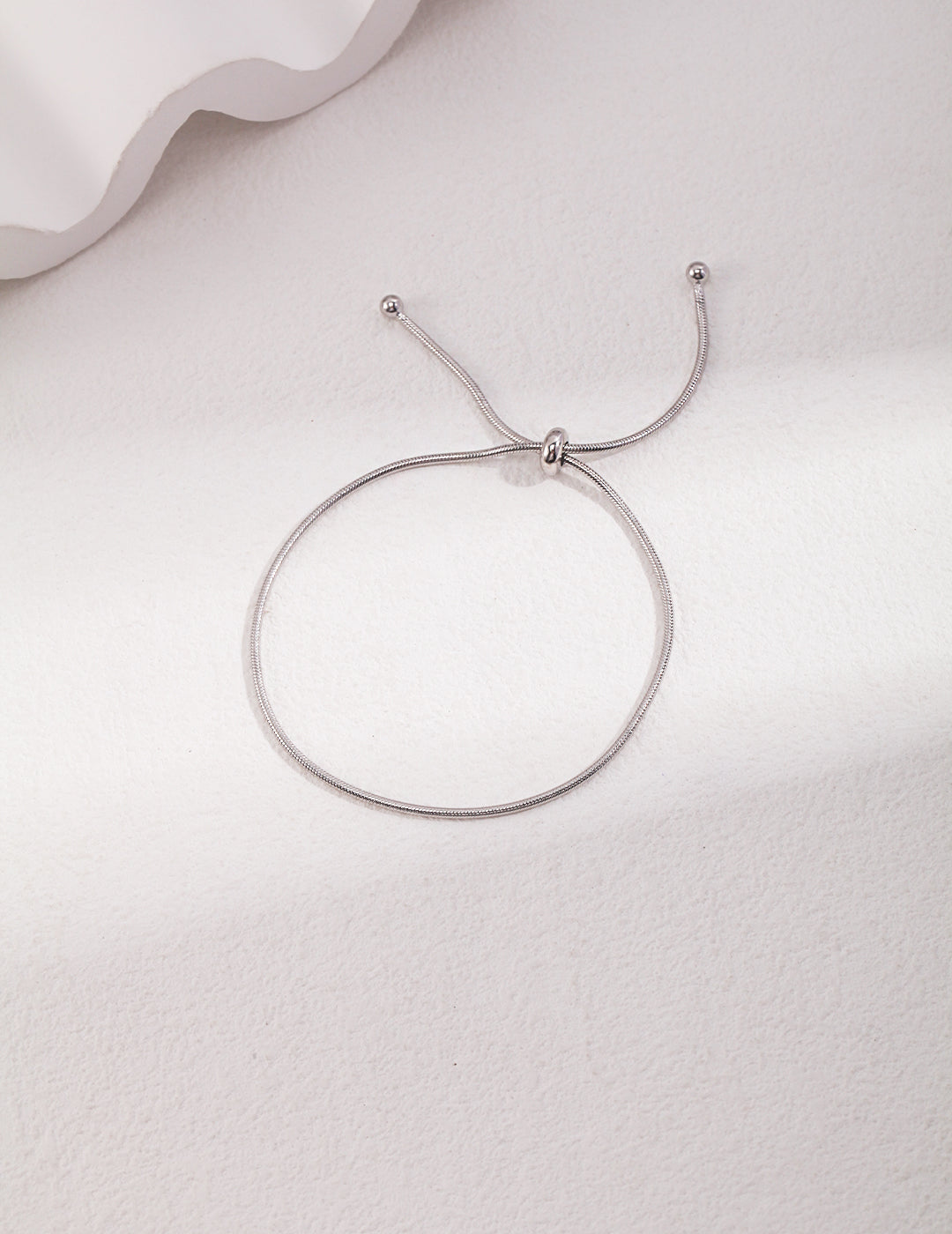 Elegant silver bracelet featuring a sliding ball clasp.