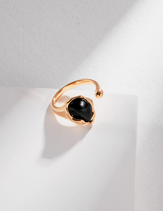 A stunning gold ring with a black agate stone, perfect for adding a touch of elegance to any outfit.