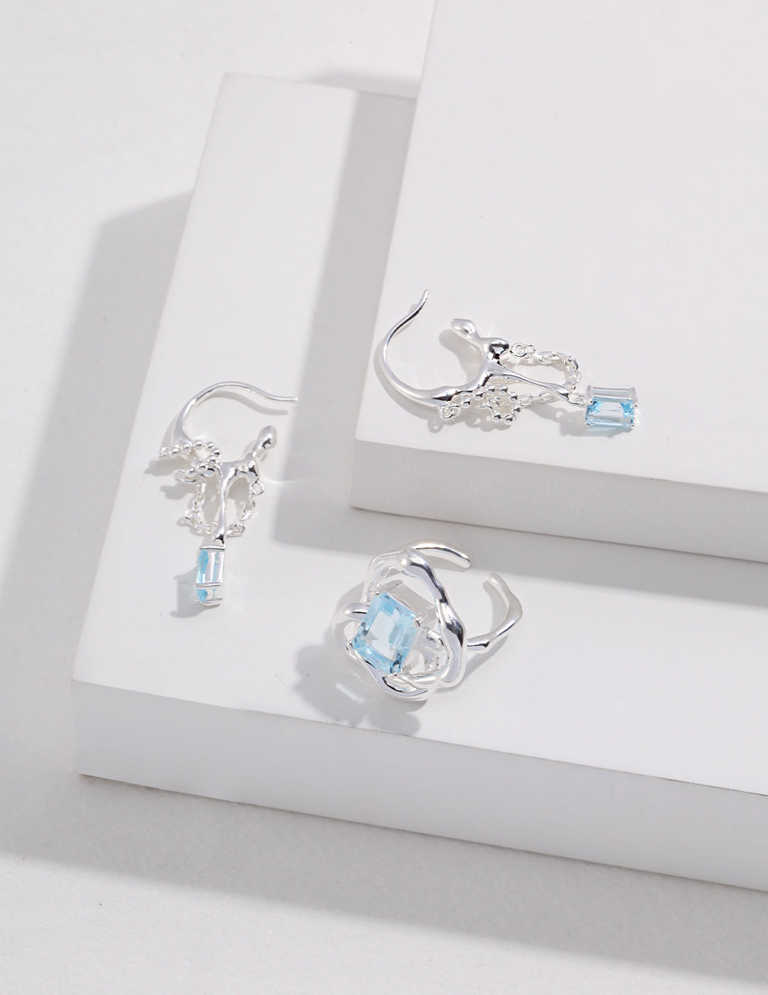 A pair of earrings with icy blue topaz stones, along with a matching ring.