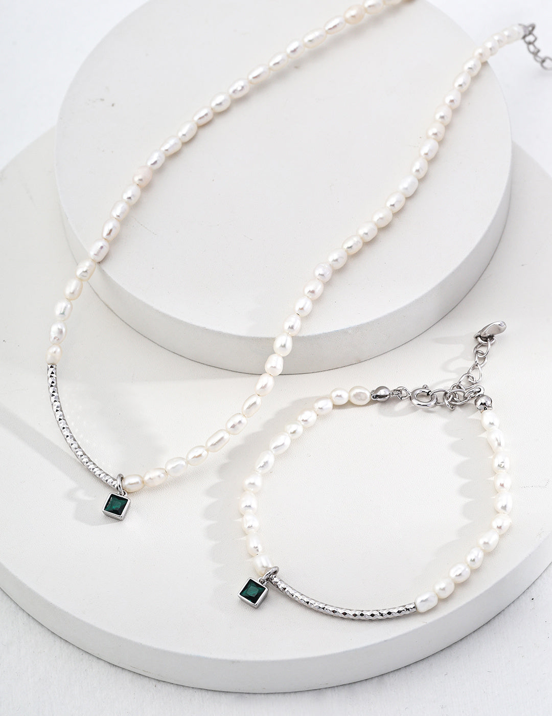 Elegant necklace and bracelet set featuring a stunning green zirconia stone, perfect for adding a touch of color to any outfit.