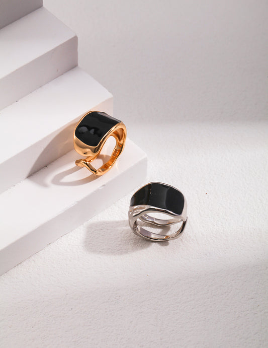 Two silver and gold rings with black enamel.