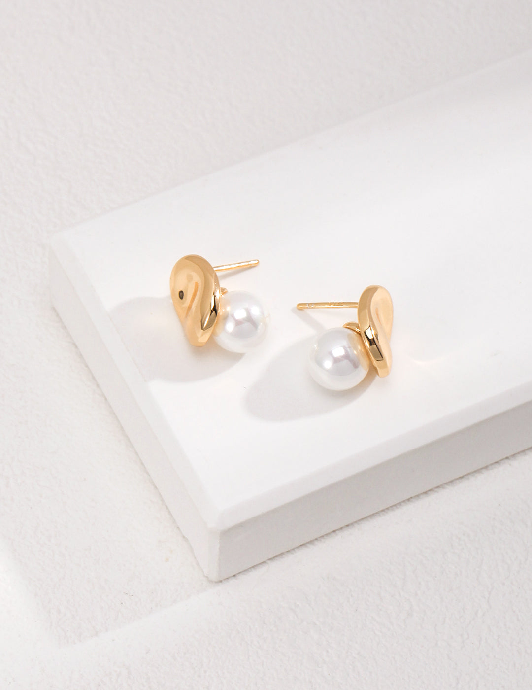 Gold jellybean studs with shell pearls.