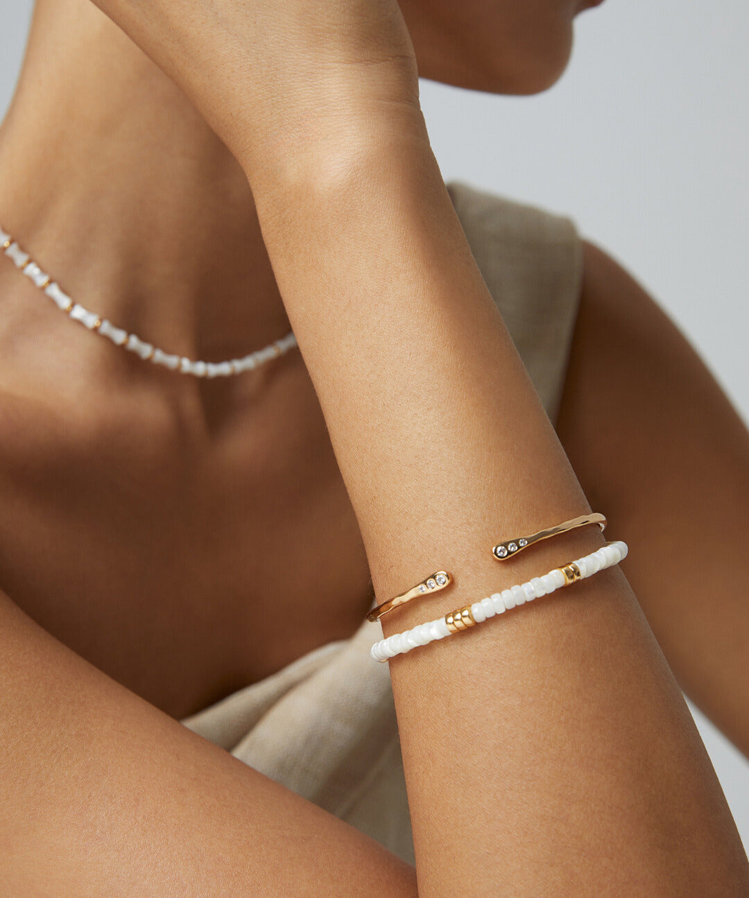 Model showcasing elegant gold bangle with delicate cubic zirconia.