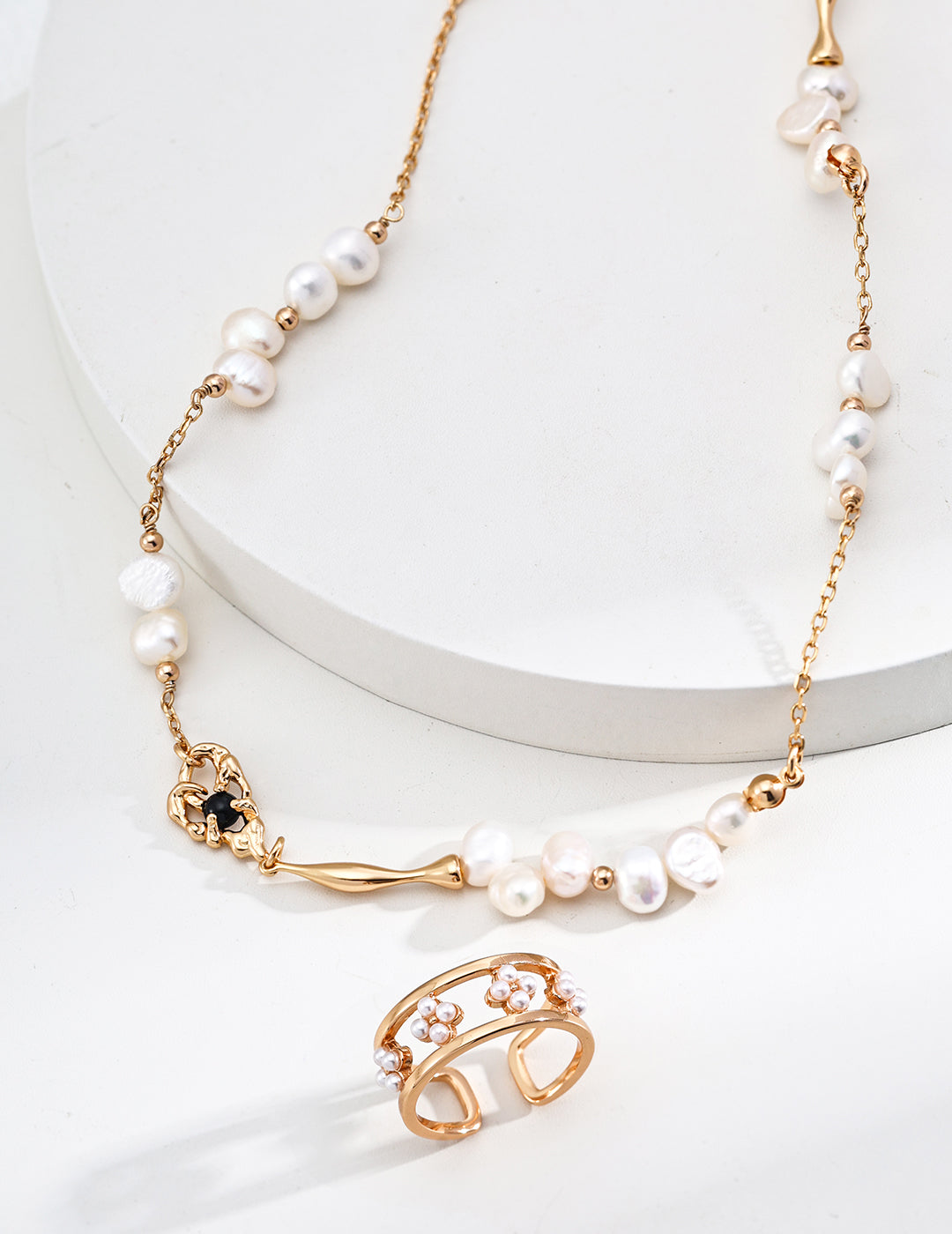 Beautiful gold pearl necklace and a shimmering shell pearl hollow designed ring, embodying sophistication and style.