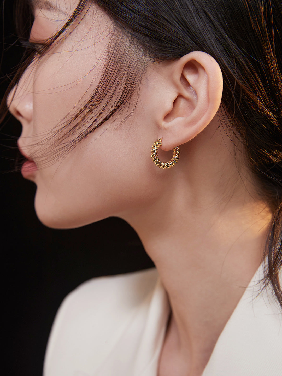 Model showcasing gold hoop earrings.