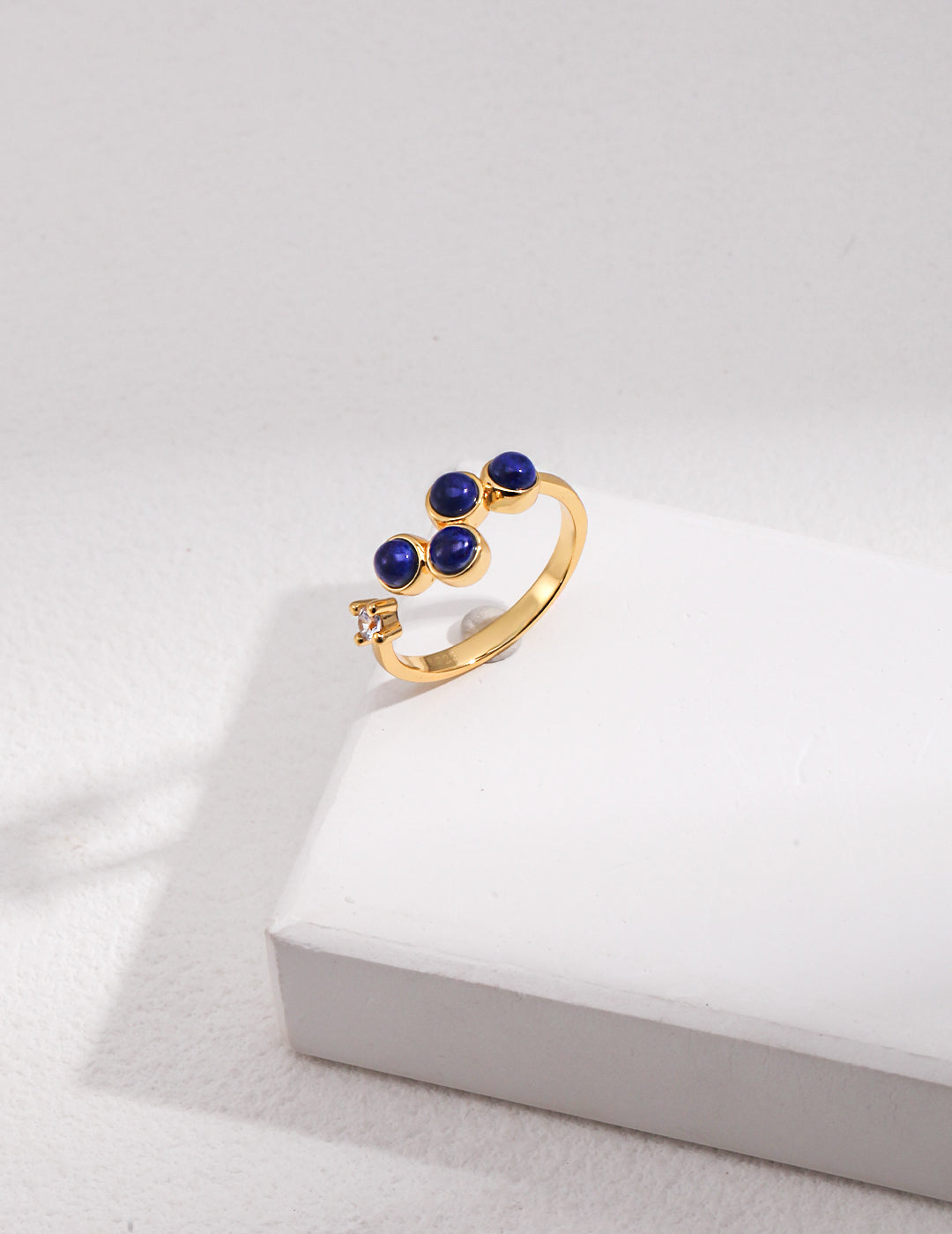 Stylish gold ring featuring vibrant blue lapis lazuli and cubic zirconia gems.