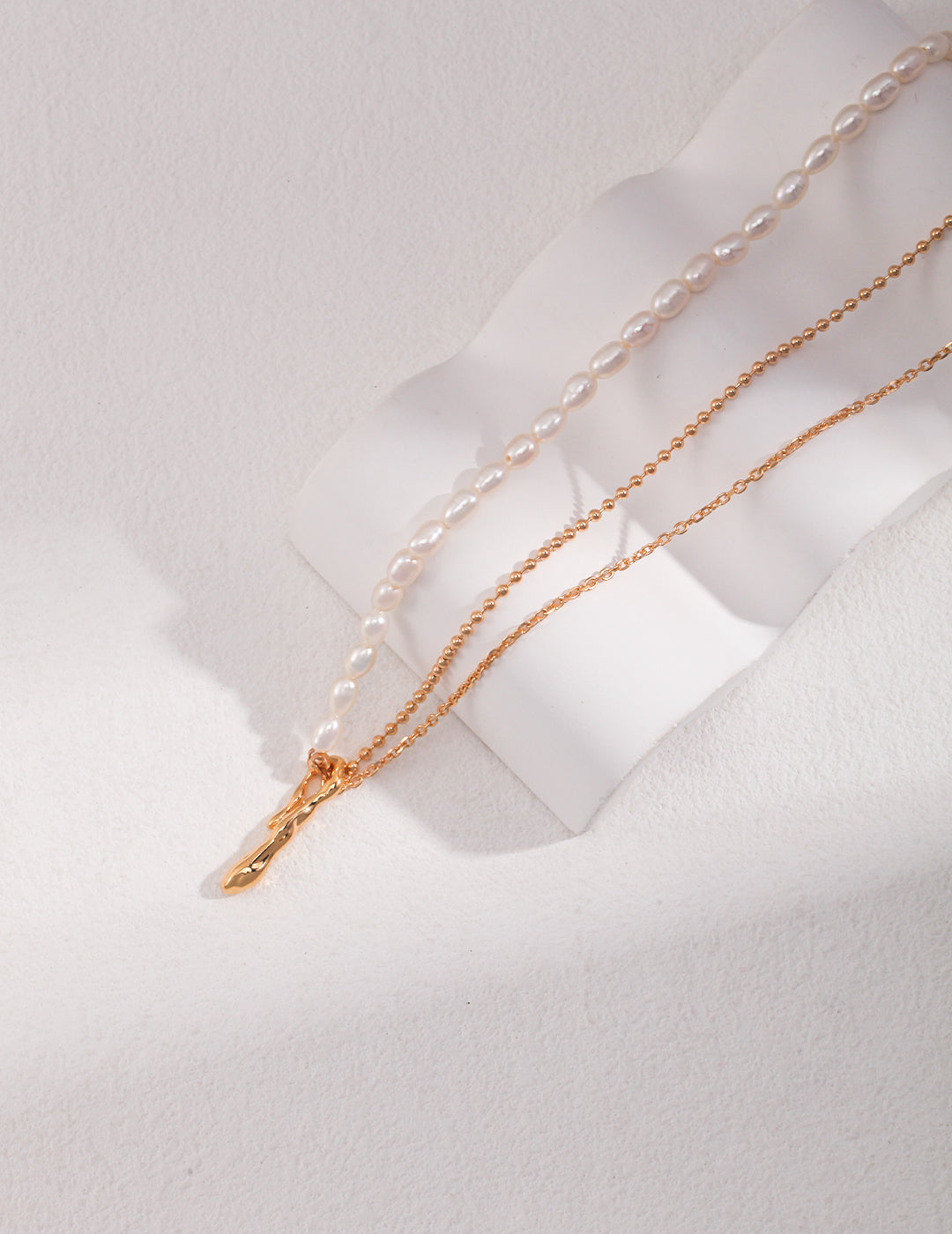 Elegant necklace that boasts a captivating design, featuring rice pearls and a half double layer chain.