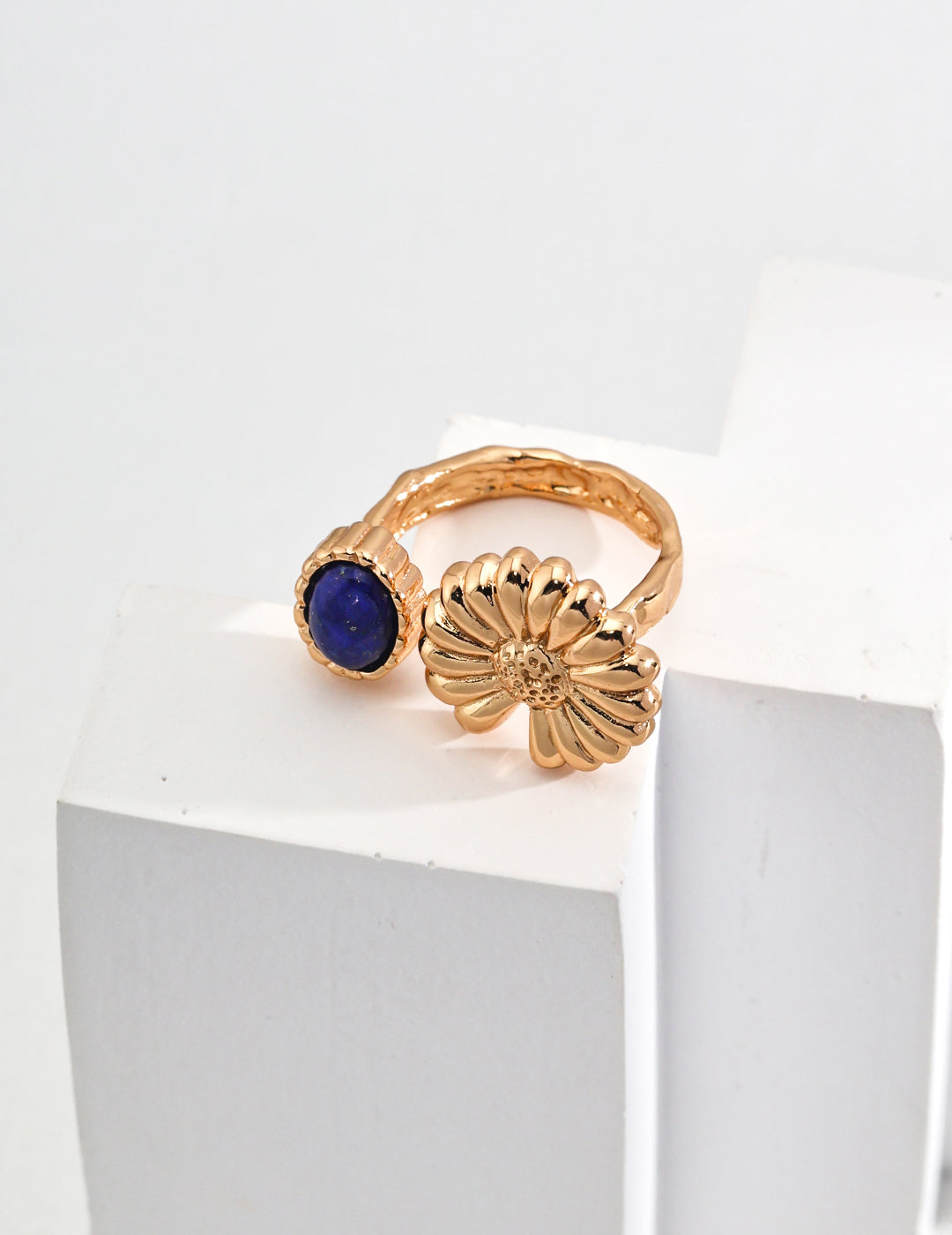 Beautiful gold ring showcasing a lapis lazuli, complemented by charming floral details.