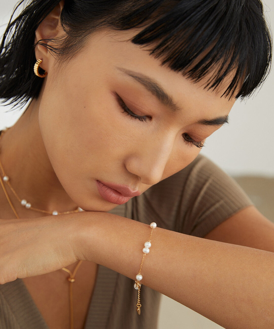 A model showcasing a gold-plated freshwater pearls bracelet and necklace, adding elegance to her attire.