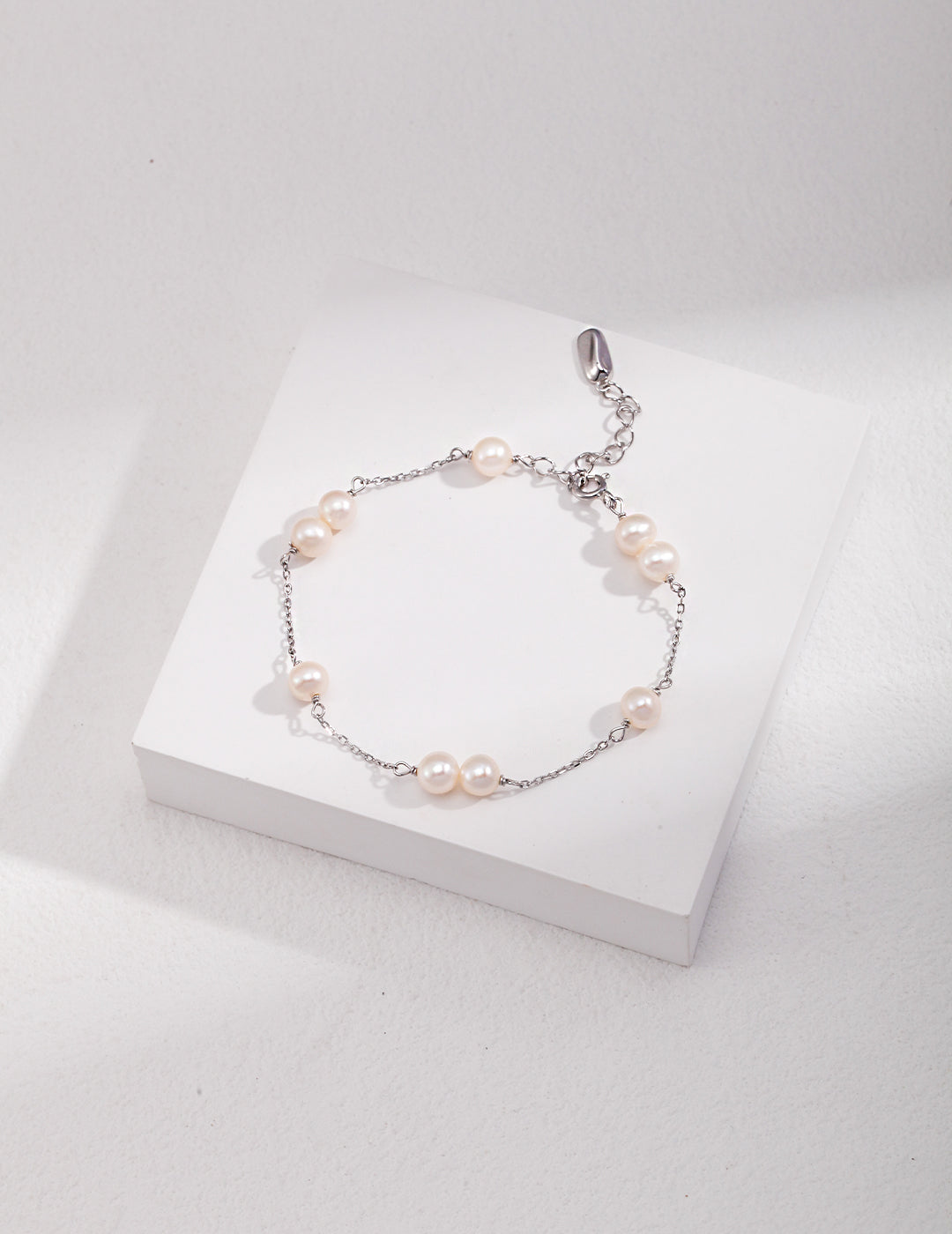 Elegant silver freshwater pearls bracelet on white box.