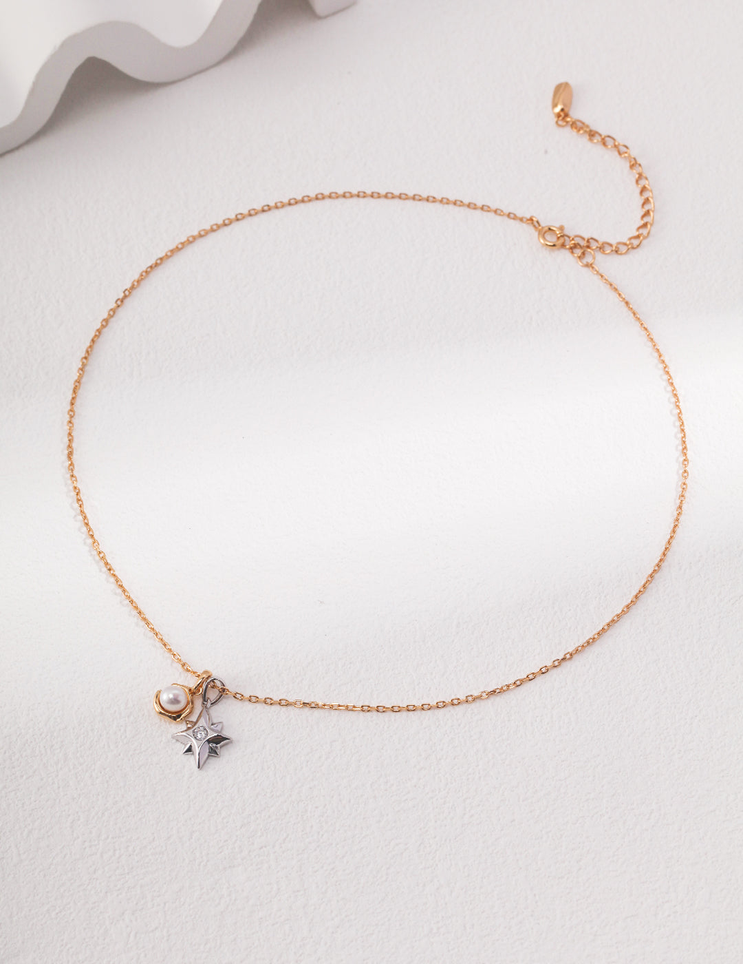 Gold chain necklace with star charm and other celestial charms, adding a touch of elegance and mystique.