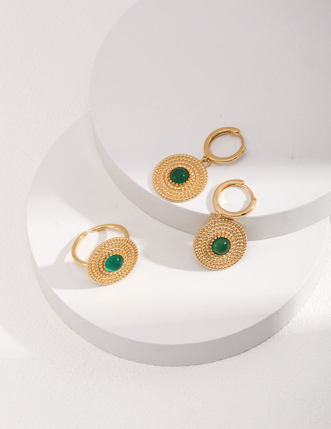 Gold plated hoop earrings with emerald stones, accompanied by a matching ring with chalcedony.