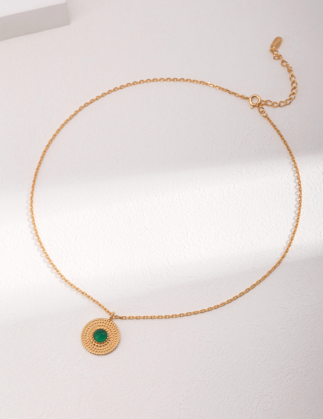 Gold necklace with chalcedony pendant featuring a stunning green stone.