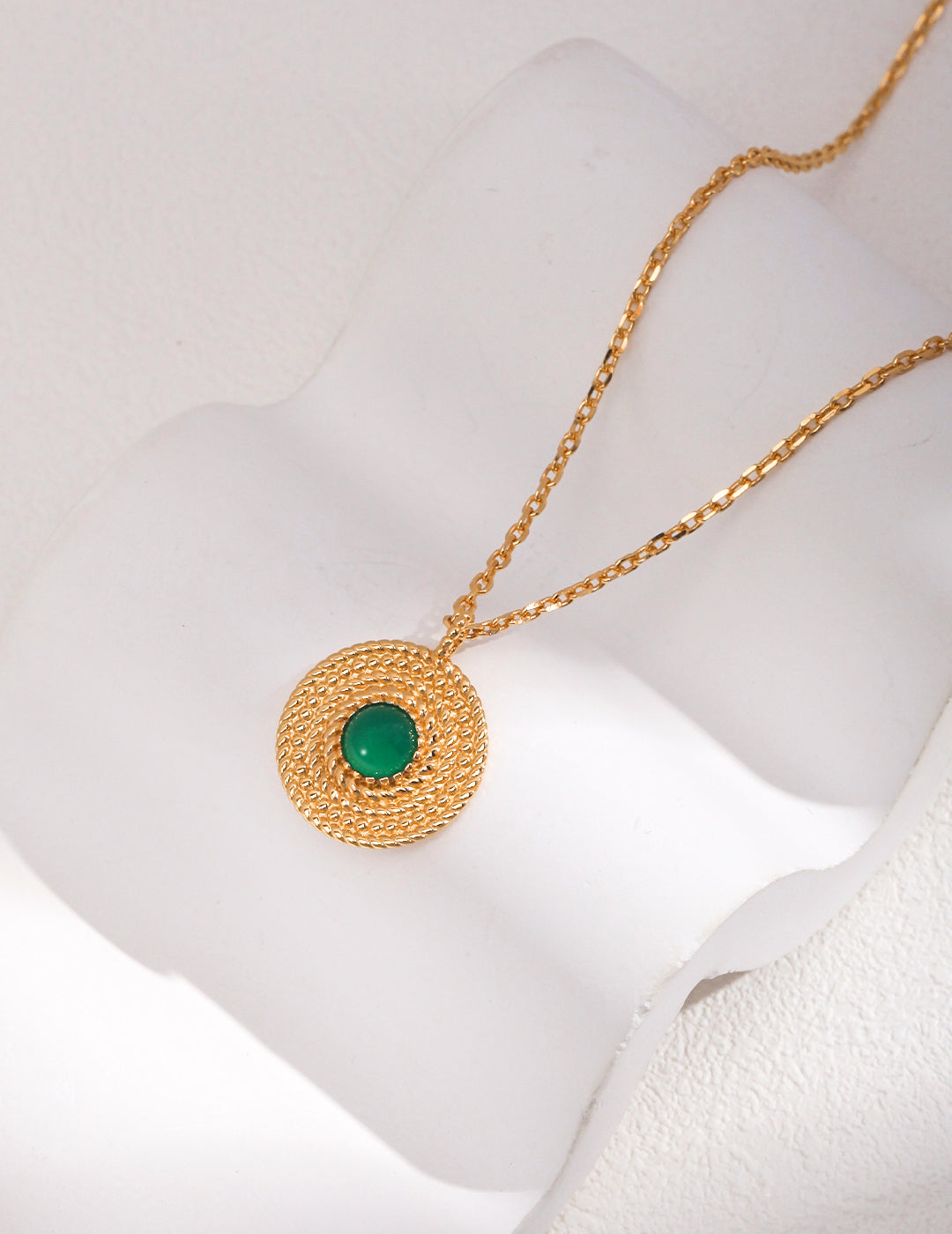 A stunning gold necklace with a captivating green chalcedony pendant.