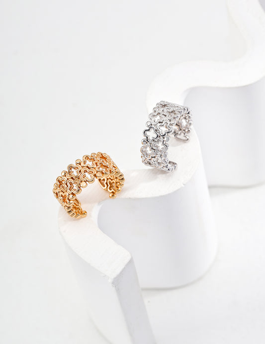 Two stylish rings in gold and silver with a clover motif, resting on a white surface, highlighting their s925 silver quality.
