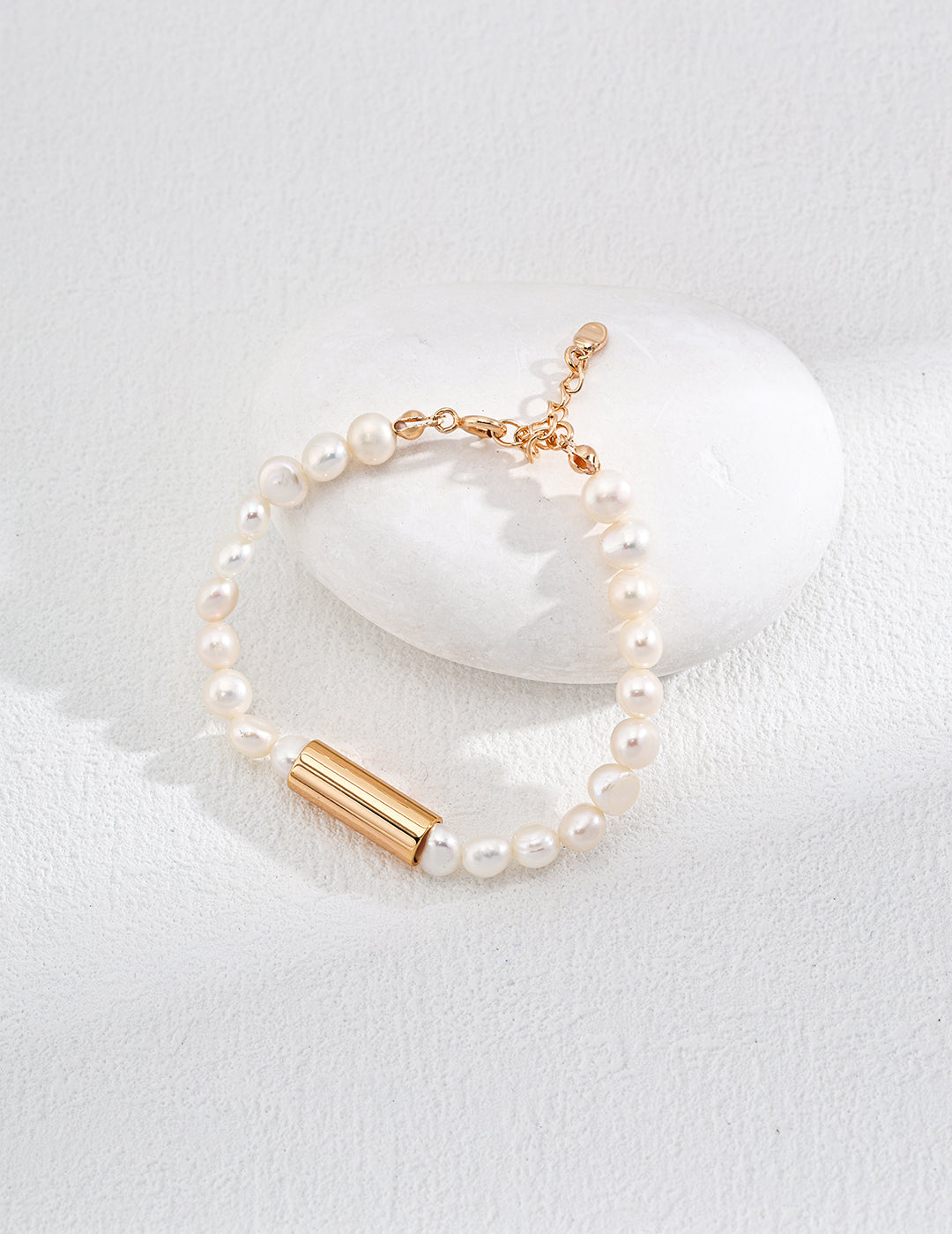 An exquisite gold-plated bracelet with a lustrous pearl bead, highlighting sophistication and timeless style.