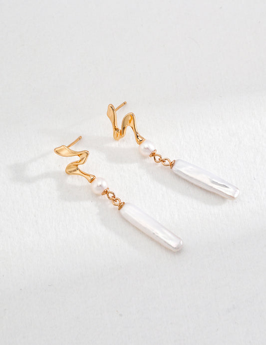 Stunning gold and white pearl earrings resting on a clean white background, highlighting their exquisite craftsmanship and beauty.