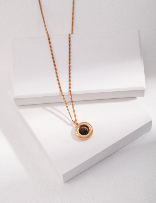 Elegant gold pendant adorned with a tiger's eye stone, highlighting its unique black and golden patterns.