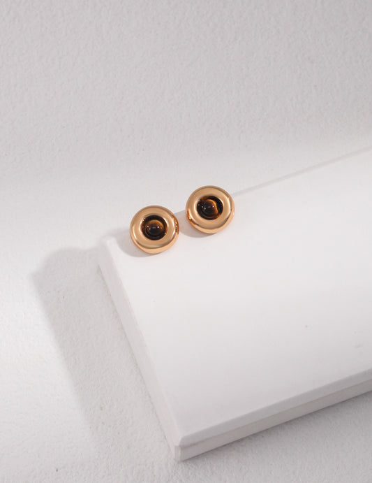 Gold earrings featuring tiger's eye studs displayed on a pristine white background.