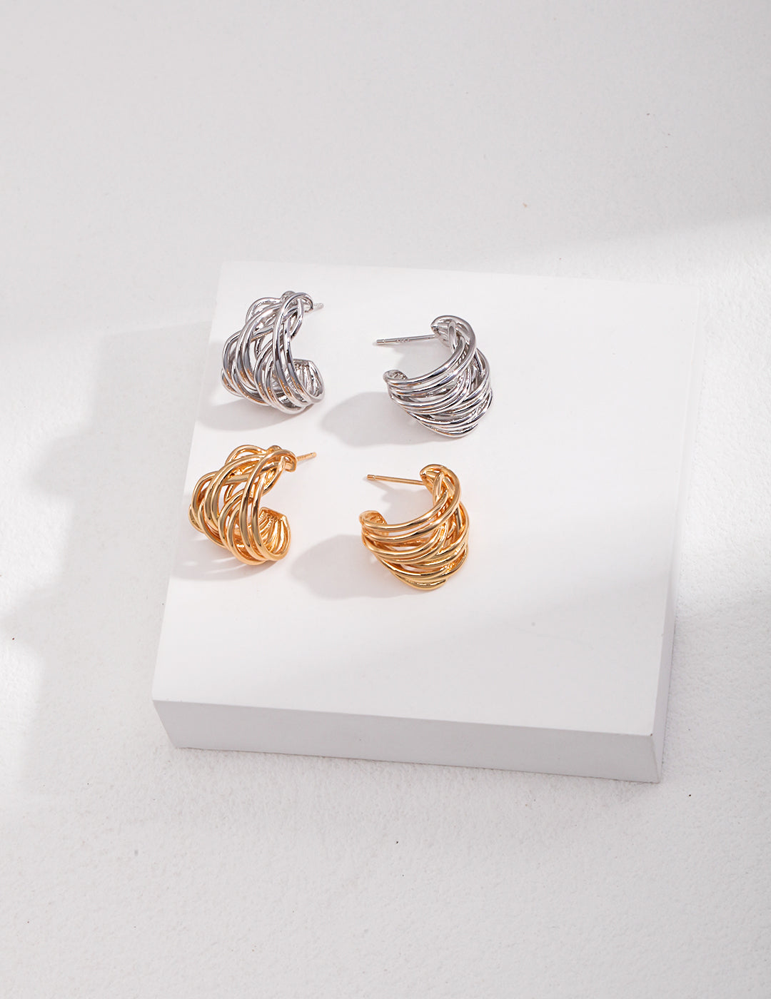 Duo hoop earrings, including one gold pair and one silver pair.