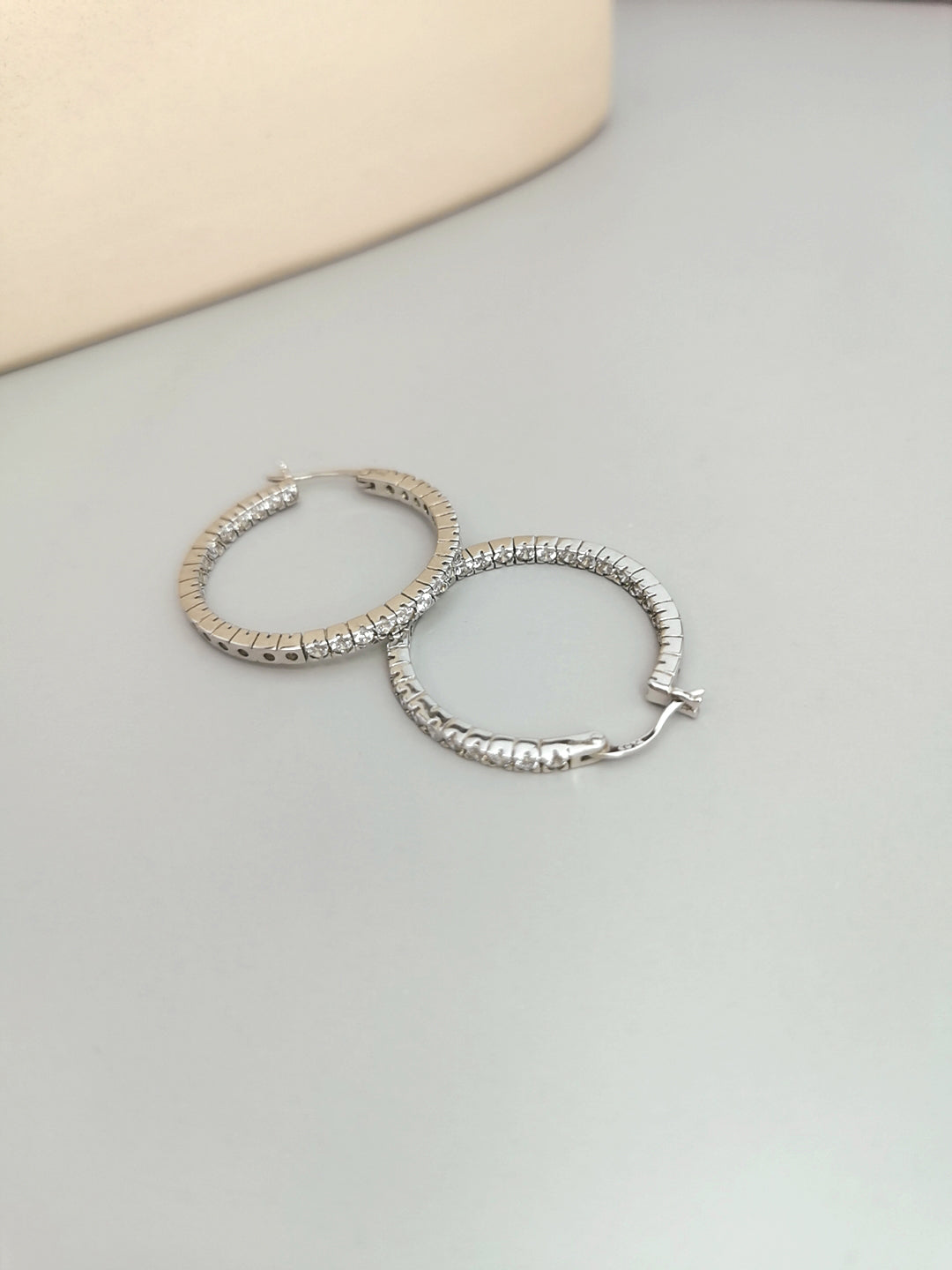 Elegant silver hoops displayed on white tabletop.