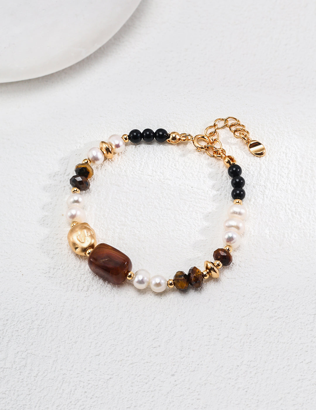 A chic bracelet with gold beads and black agate, combining with tiger's eye for a sophisticated accessory.