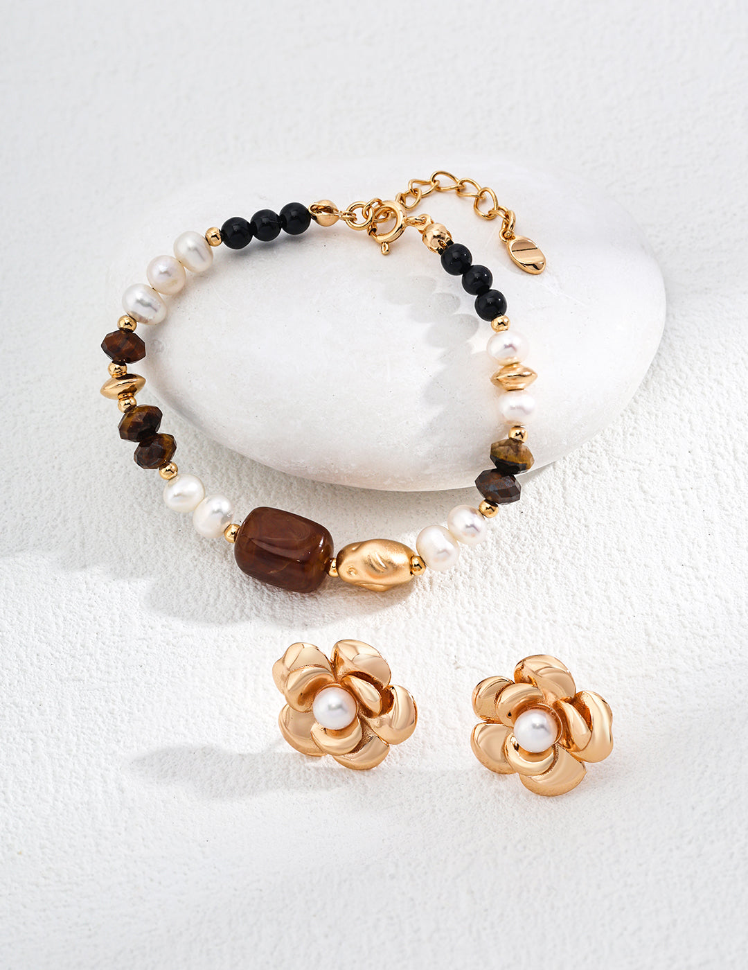 Beautiful bracelet and earrings set adorned with gold, black agate, and tiger's eye beads for a chic look.