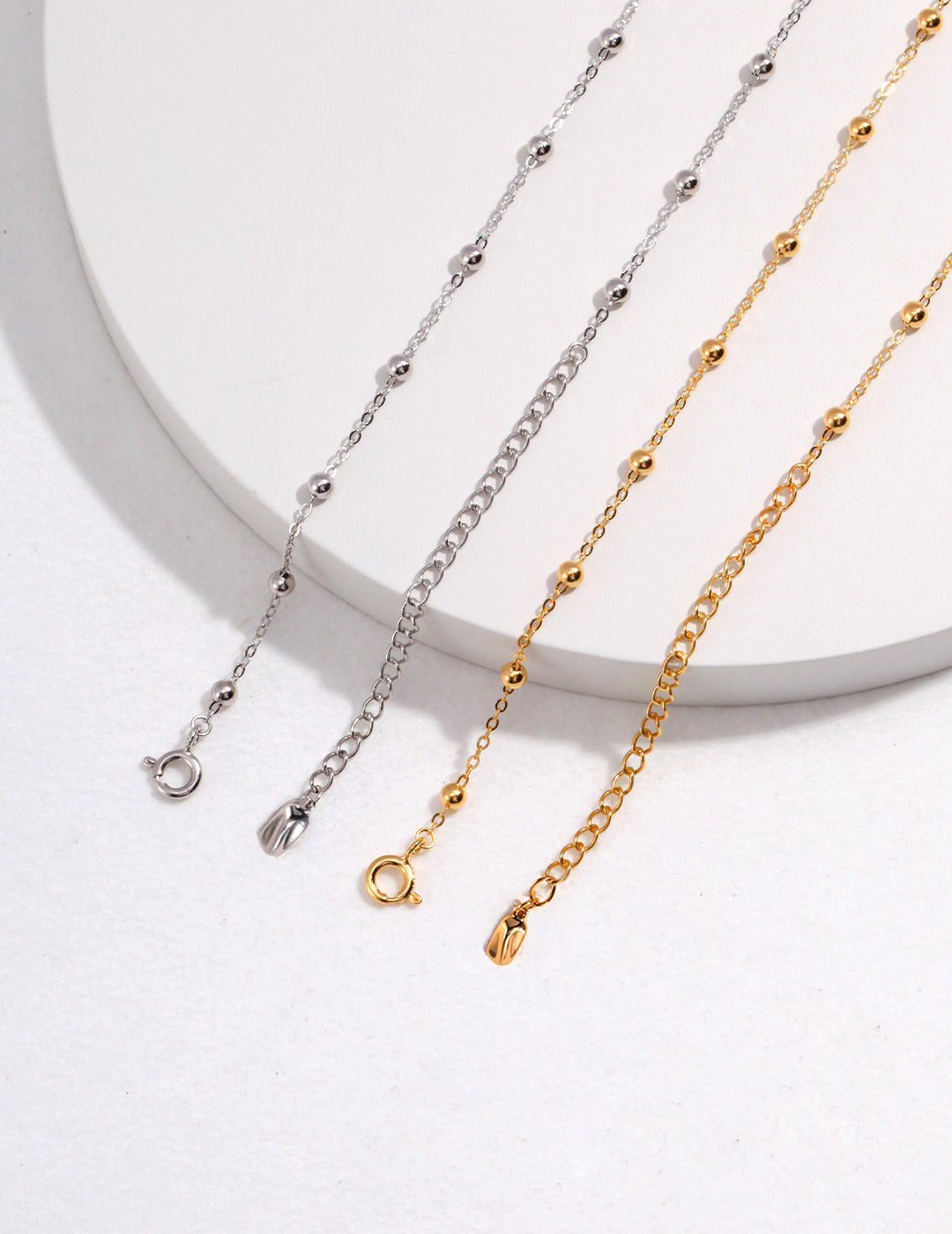 Close up shots of gold and silver necklaces with beads interspersed