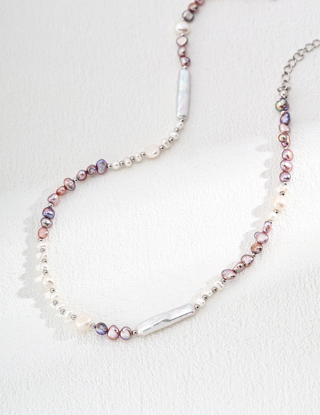 Elegant lavender necklace with a silver chain and a delicate pearl strand, perfect for adding a touch of class to any outfit.