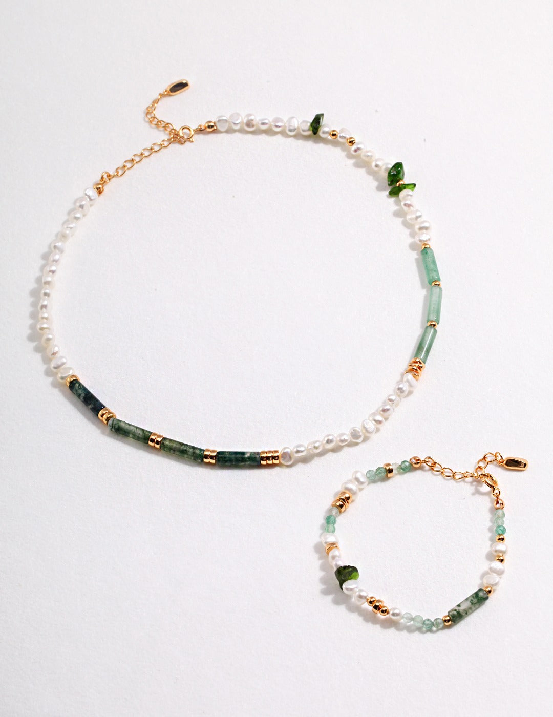 A stunning green and gold jewelry set featuring a matching necklace and bracelet. Perfect for any occasion.