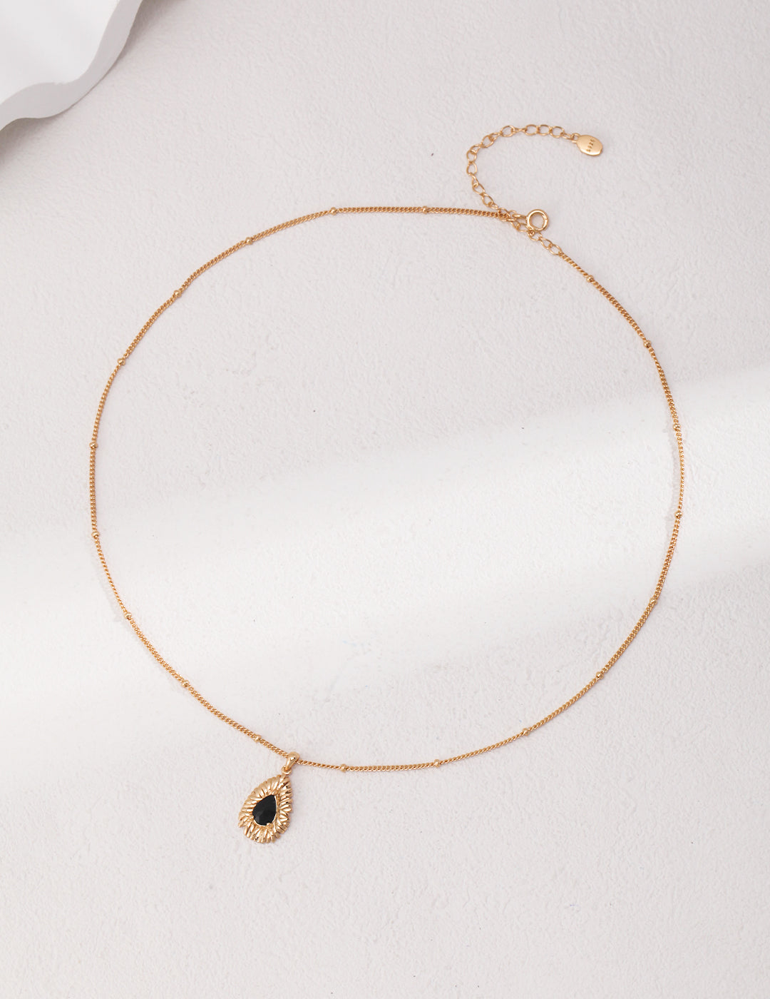 Gold necklace with black carbonado diamond charm.