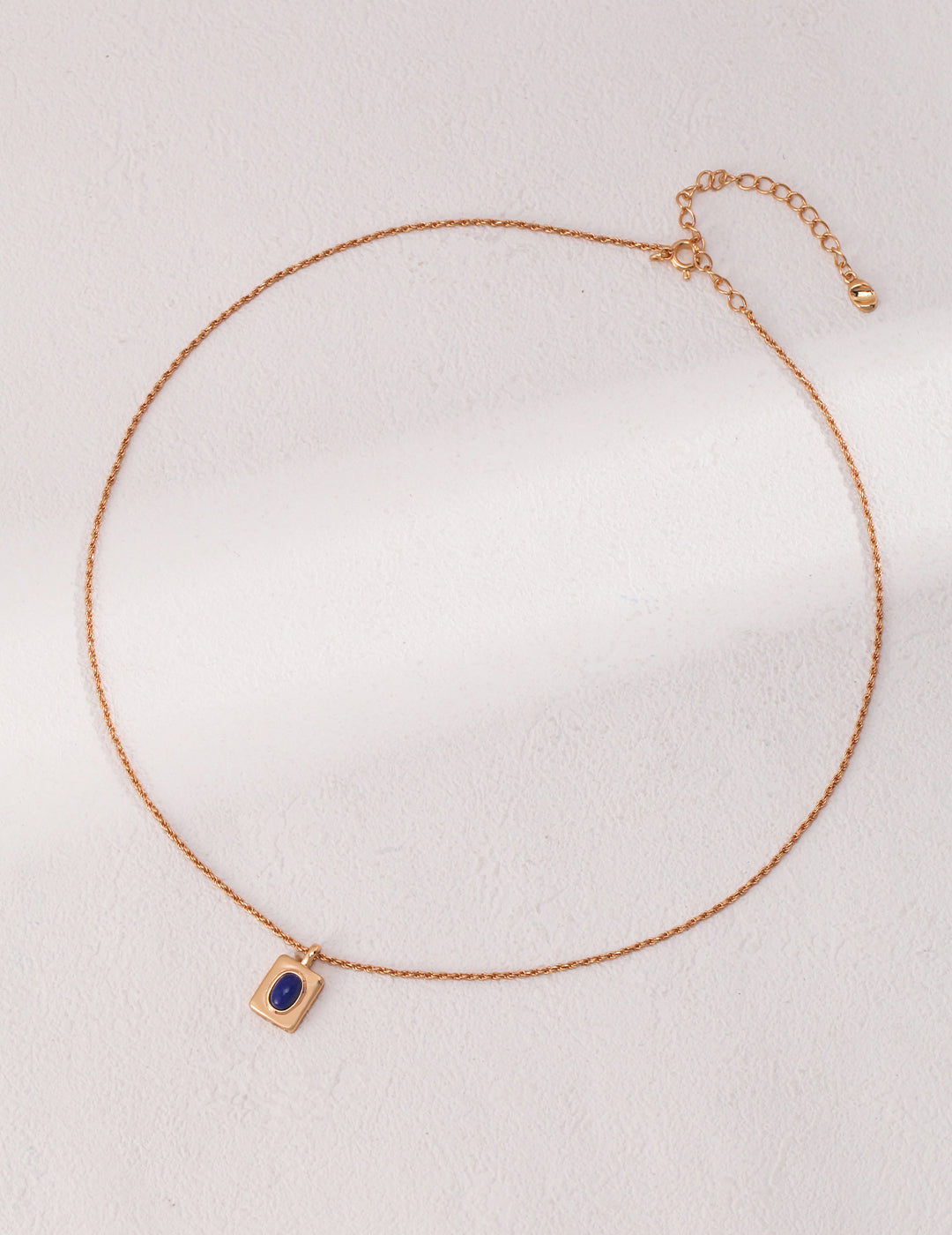 Luxurious gold necklace featuring a stunning blue lapis lazuli stone pendant.