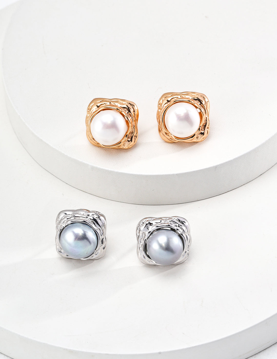 Two pairs of elegant earrings with white and grey pearl studs