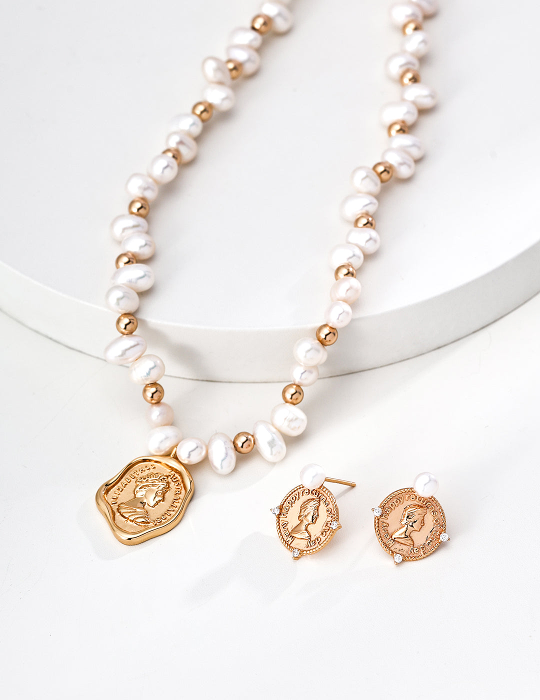 Pearl necklace with gold coin-shaped accents and matching earrings on a white background, freshwater pearls in S925 Silver by Mezuille, everyday jewelry.