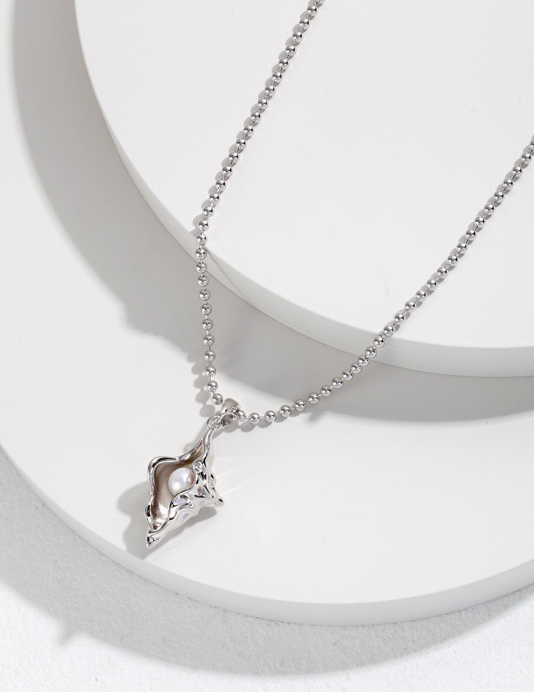 A delicate silver necklace featuring a charming seashell pendant, perfect for expressing love and affection.