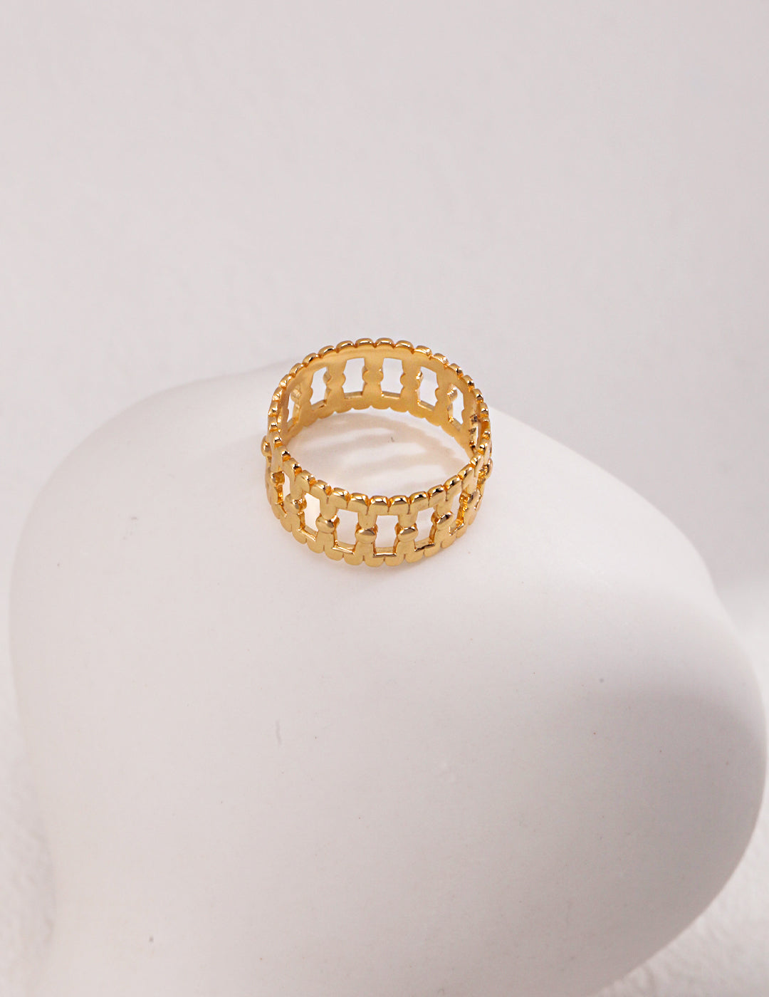 A hollow gold ring with a diamond pattern on top, adding elegance and sparkle to any outfit.