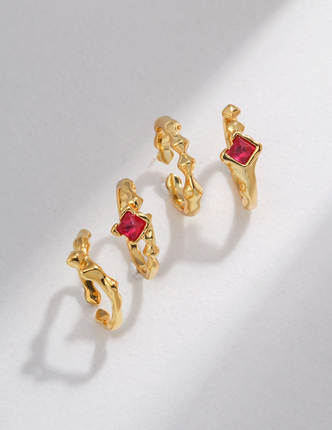 Assorted gold rings featuring vibrant red stones.