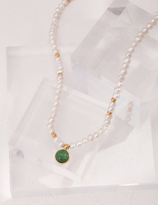 A vintage necklace with a green agate pendant and freshwater pearls.