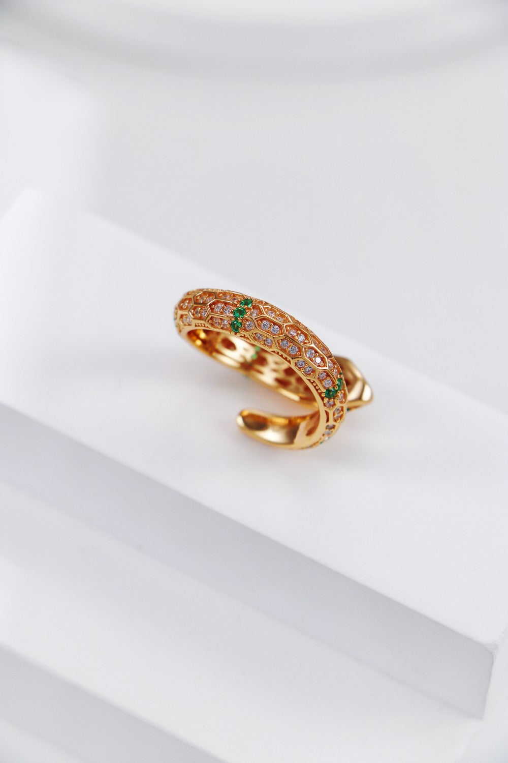 A detailed view of the back of a gold snake ring adorned with sparkling zirconia , showcasing its intricate design.