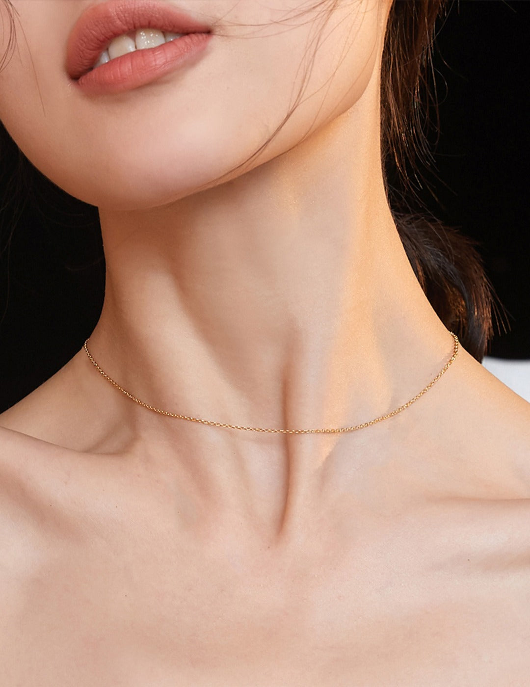 Model showcasing elegant gold chain necklace.