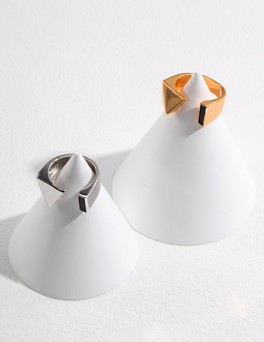 A gold and a silver enamel rings placed on a white cone.