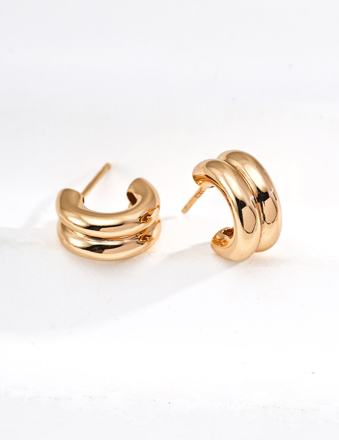 A pair of clean gold half-hoop earrings in S925 Silver by Mezuille on a white background.