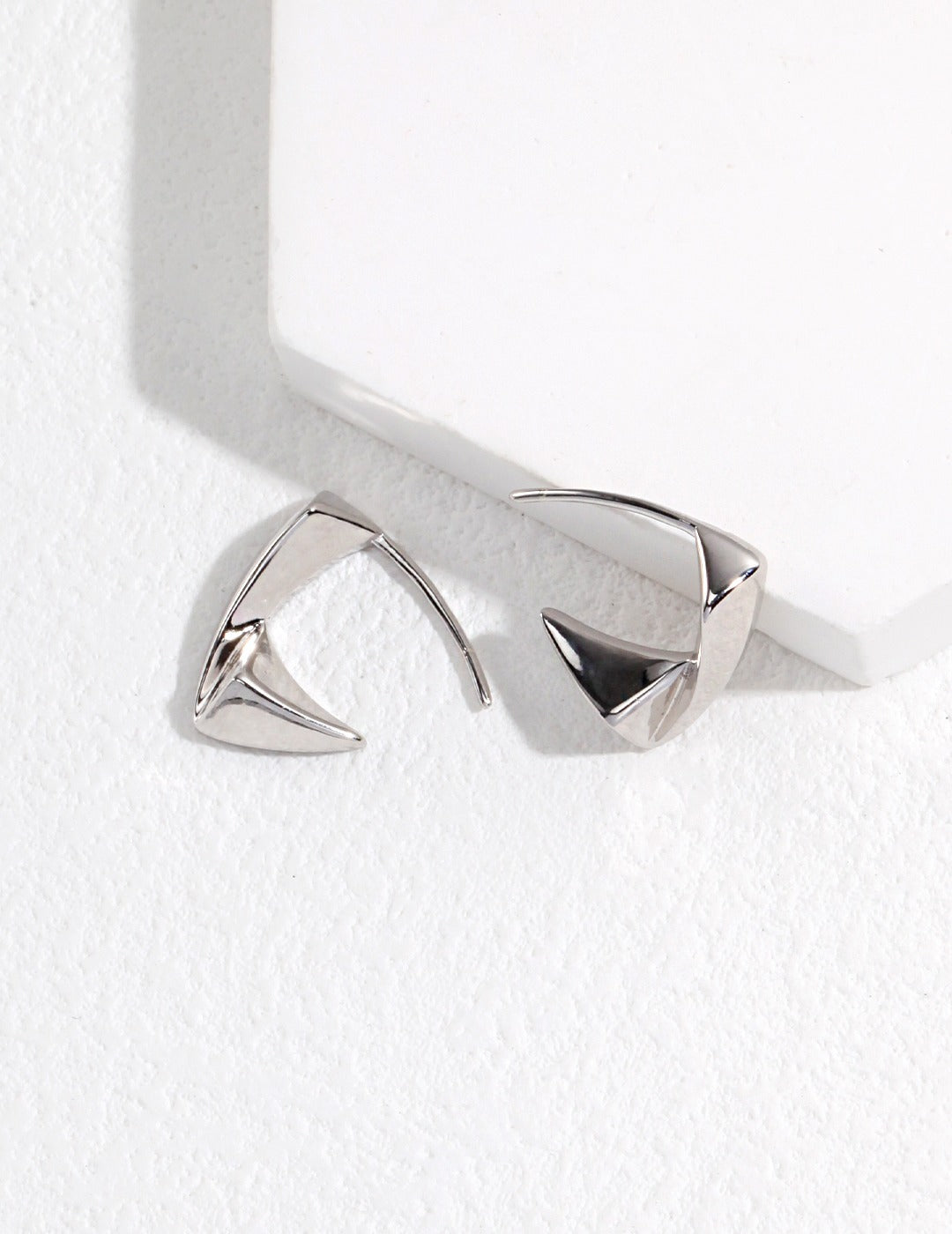 Silver hoop earrings with triangle shape.