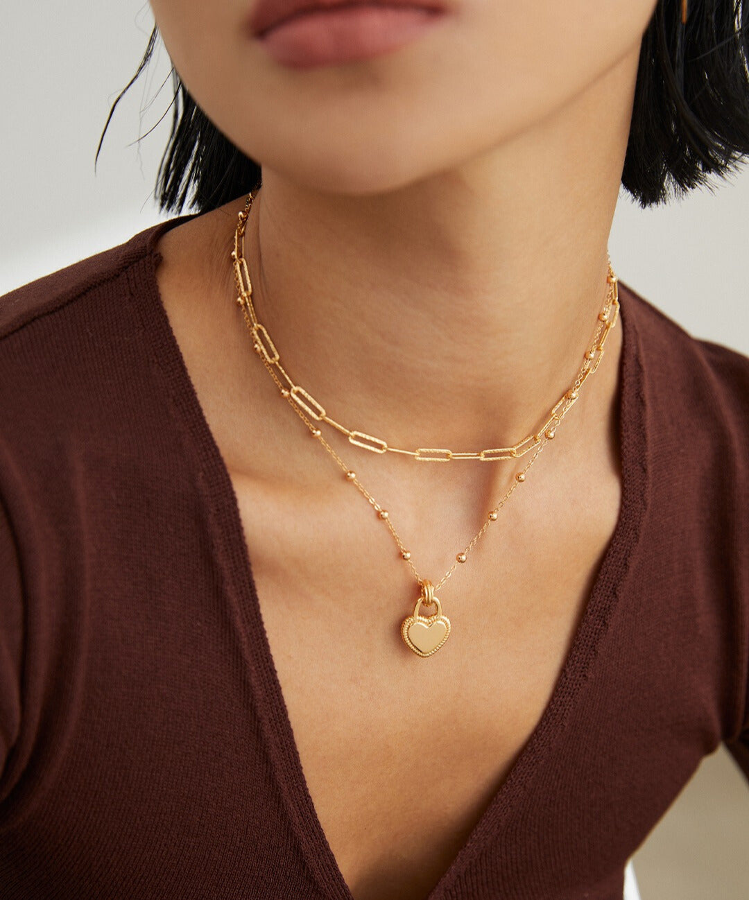 Gold plated necklace with gold heart pendant worn by model.