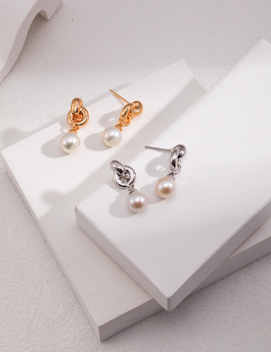 Stunning interlocked silver and gold earrings featuring beautiful freshwater pearls.