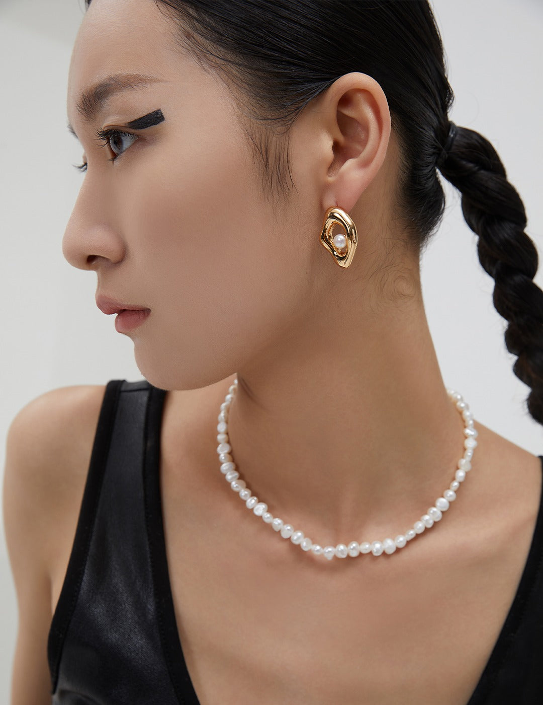 Portrait-style view of a model in a black top wearing the Miley Necklace, illustrating the refined, everyday elegance of the piece.